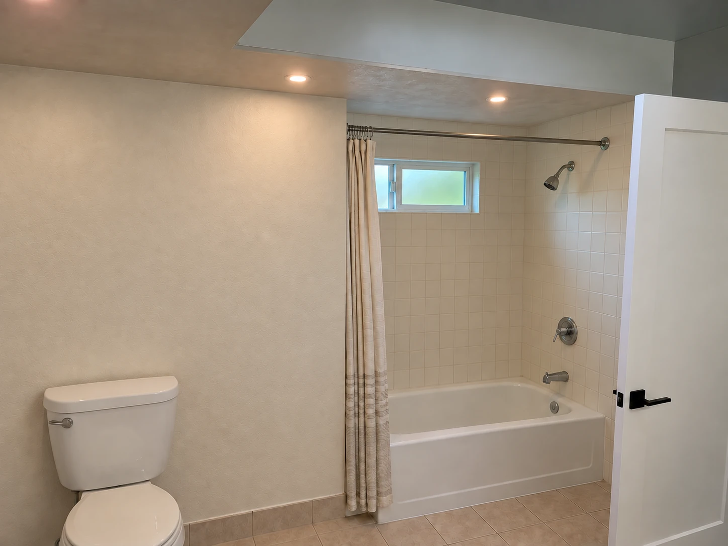 Bathroom before concept with a toilet on the left and an older bathtub and shower on the right